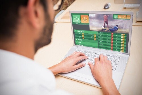 Man placing sports bets on his computer